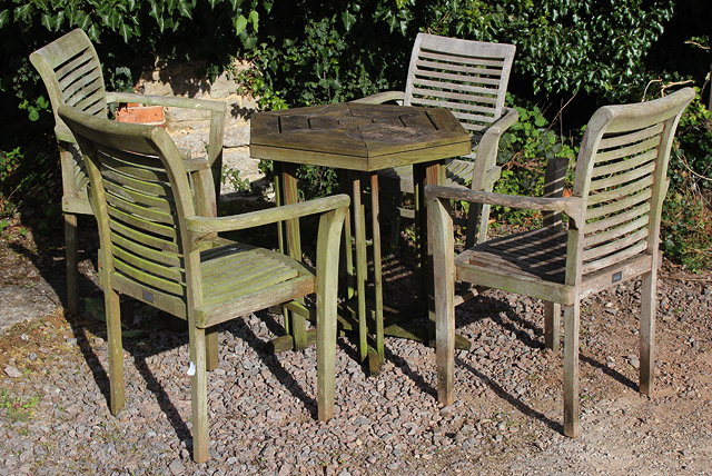 Appraisal: A SET OF FOUR TEAK GARDEN OPEN ARMCHAIRS with slatted