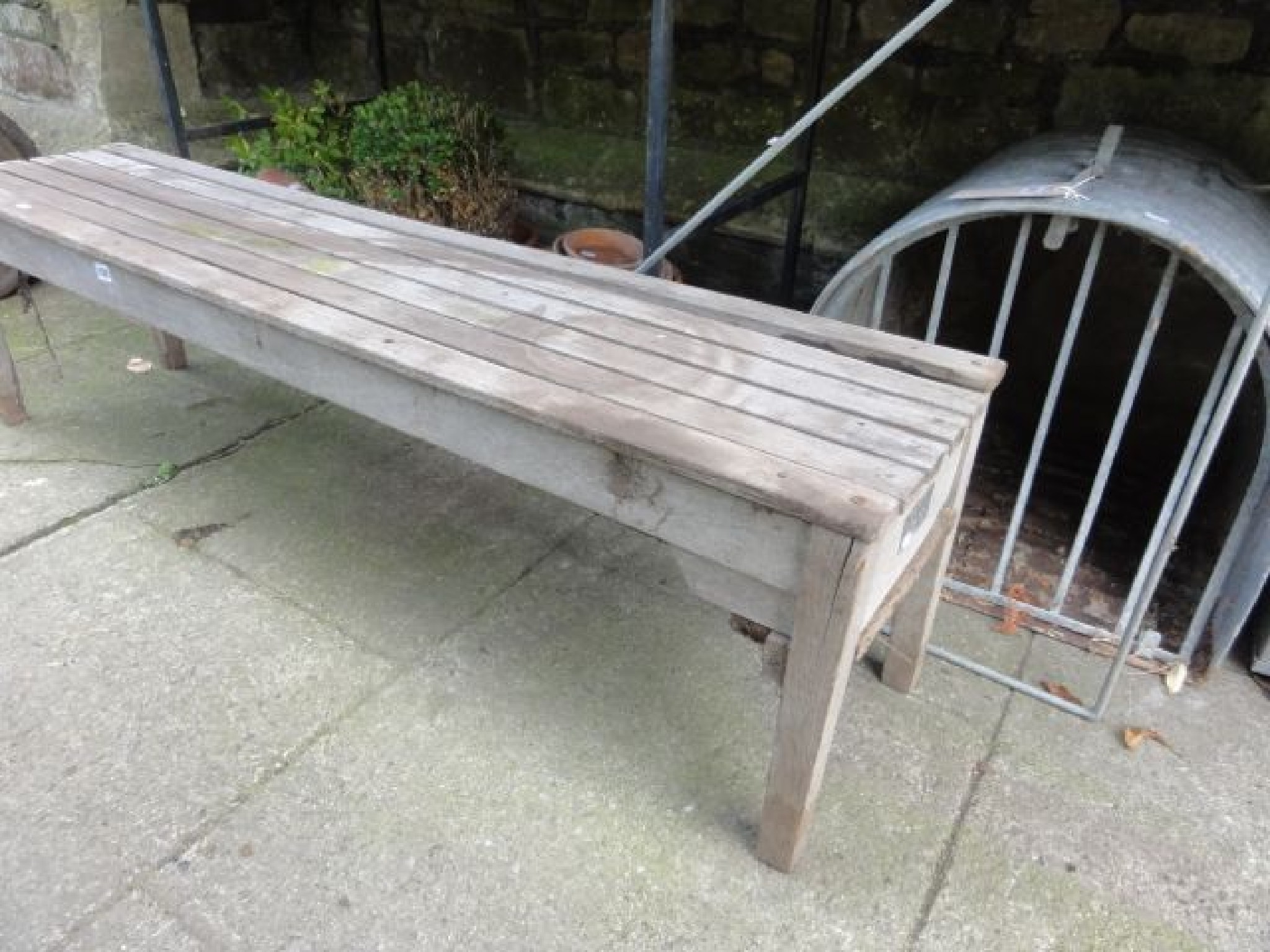 Appraisal: An R A Lister weathered teak garden bench of rectangular