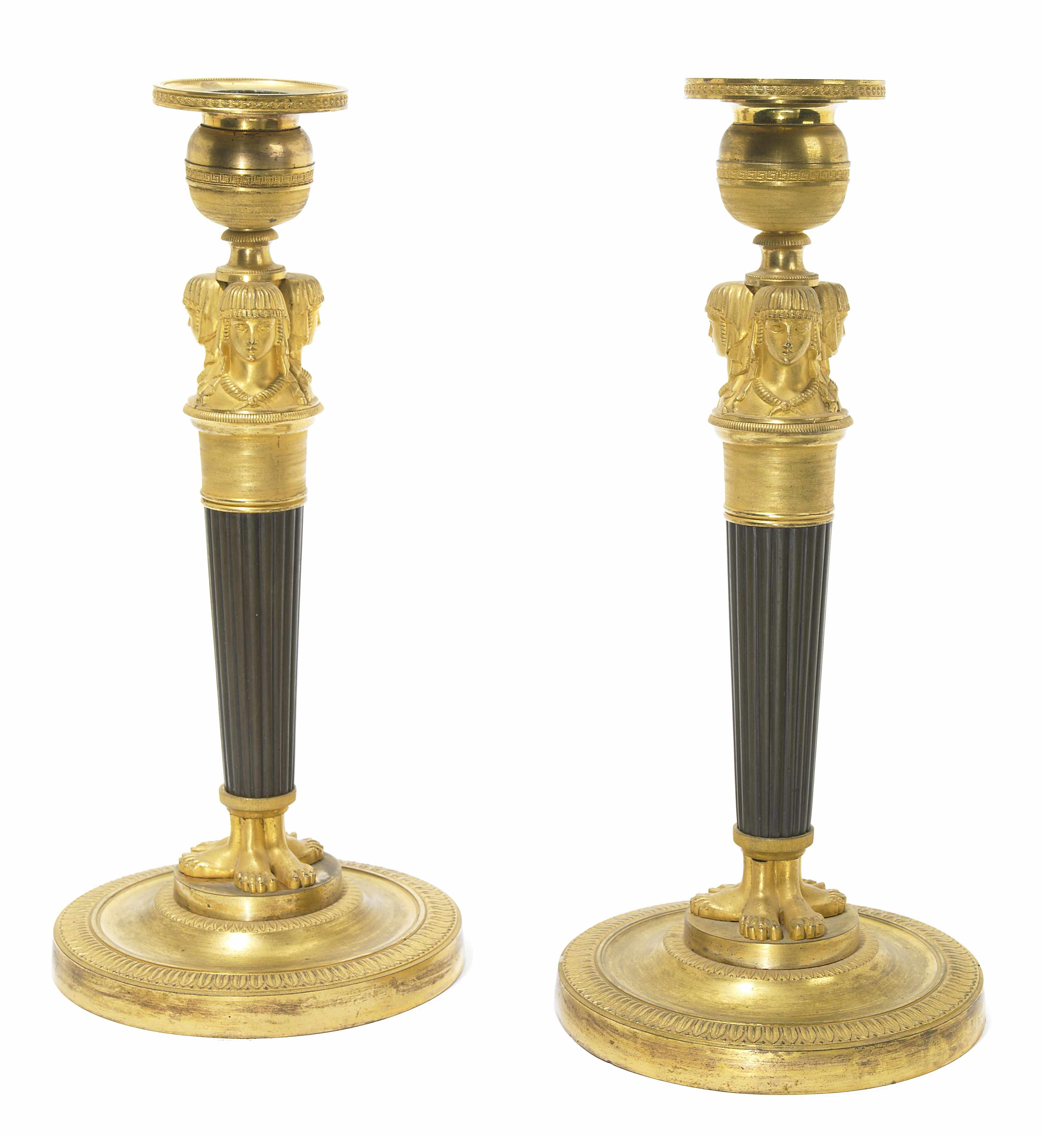 Appraisal: A pair of Empire gilt and patinated bronze candlesticks early