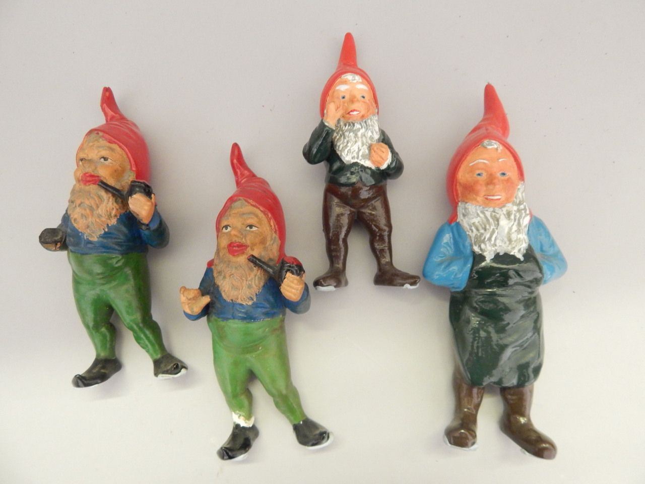 Appraisal: Four painted terracotta garden gnomes to include two figures with