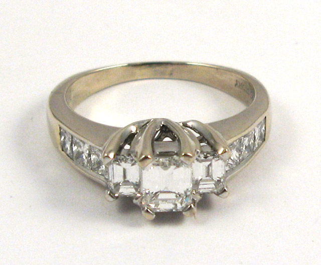 Appraisal: DIAMOND AND FOURTEEN KARAT WHITE GOLD RING featuring three princess-cut