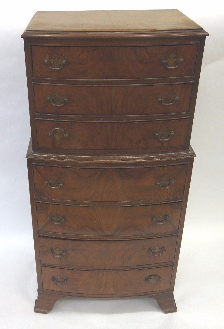 Appraisal: A reproduction figured walnut bowfronted tallboy fitted with seven drawers