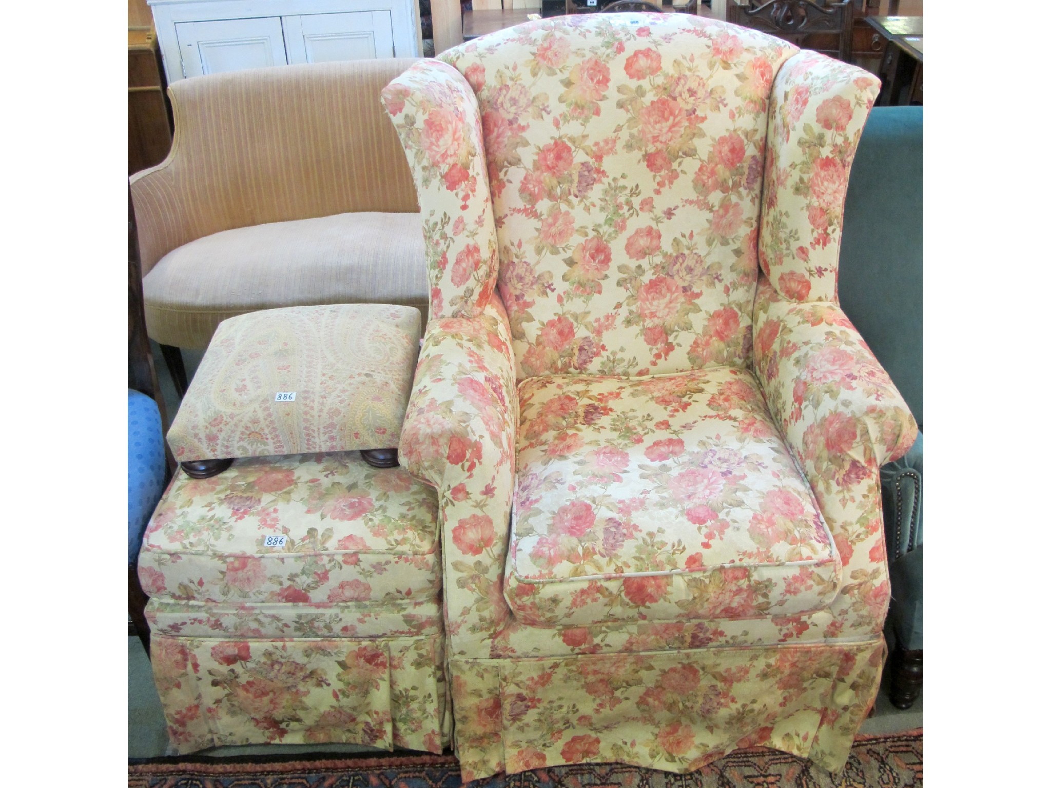 Appraisal: A contemporary floral wingback chair and footstool and a small