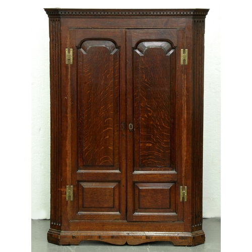 Appraisal: A George III splay fronted oak corner cupboard with ogee