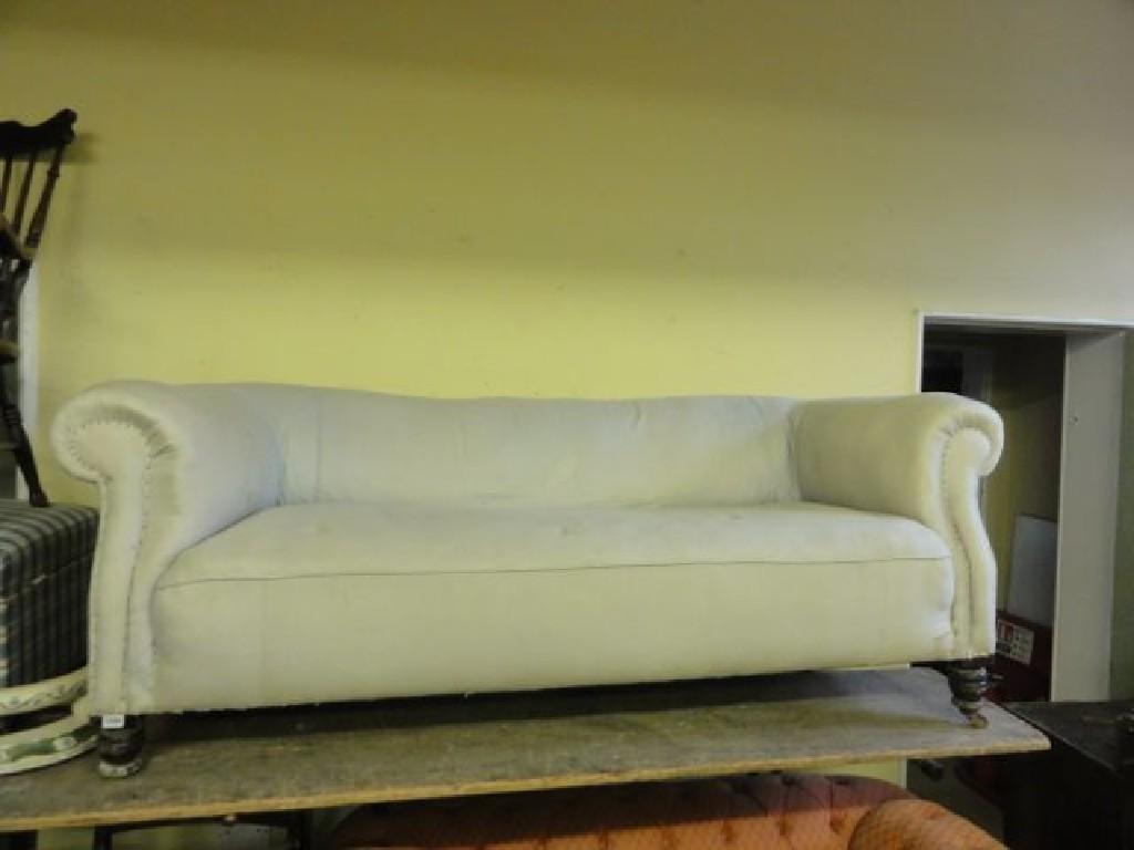 Appraisal: An Edwardian three seat Chesterfield sofa with rolled arms simply