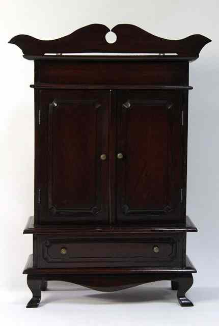 Appraisal: A miniature cabinet with shaped cornice above two doors and