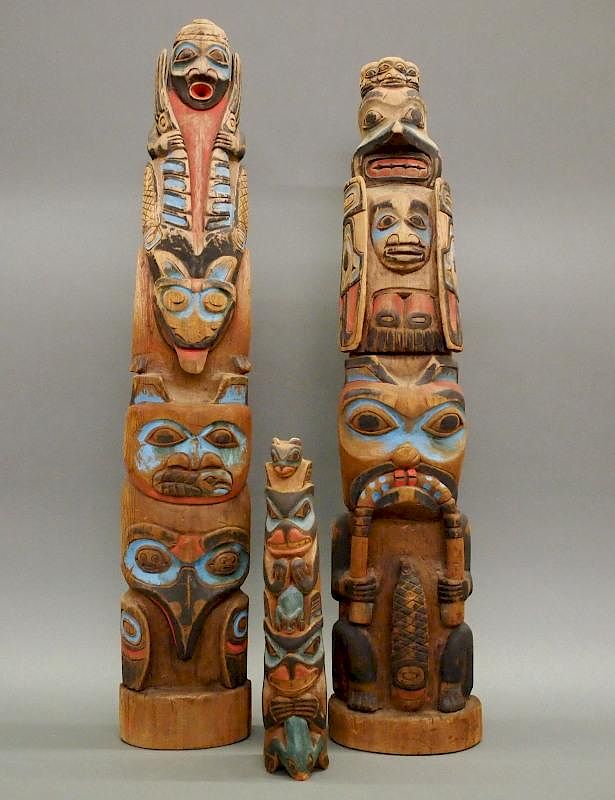 Appraisal: Northwest totems Three Northwest Coast totem poles Carved cedar with