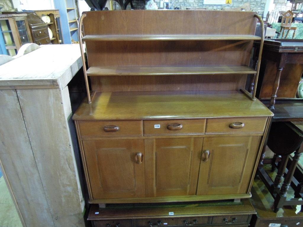 Appraisal: An Ercol oak dresser the base fitted with three frieze