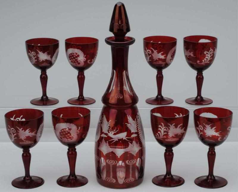 Appraisal: Ruby Bohemian Decanter Wine Goblets Description Etched ruby to clear