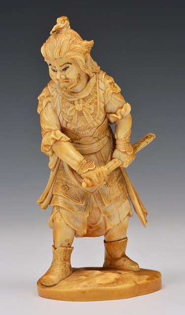 Appraisal: A JAPANESE IVORY OKIMONO carved as standing figure of Bishamonten