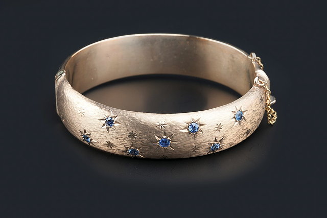 Appraisal: A CT GOLD AND SAPPHIRE SET BANGLE of hinged oval