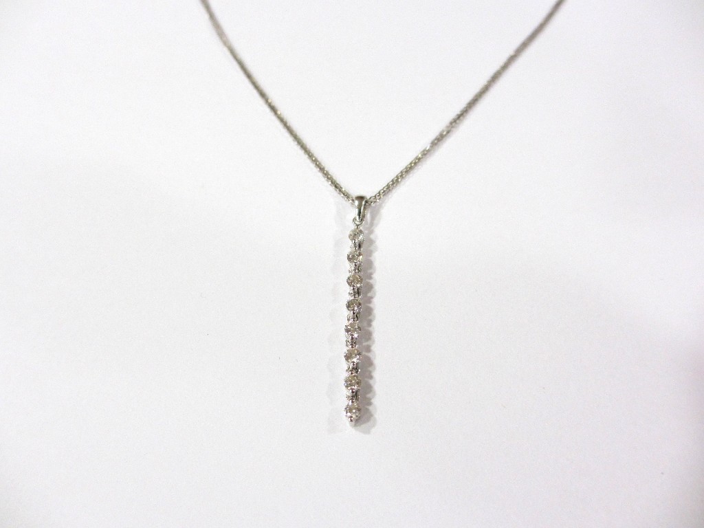 Appraisal: A diamond pendant designed as a line of eight small