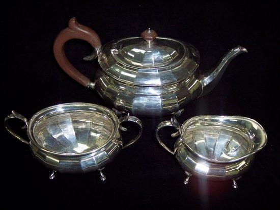 Appraisal: A three-piece tea service of faceted oval shape raised on