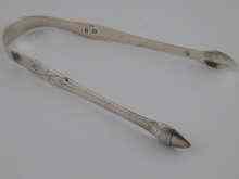 Appraisal: A pair of bright cut silver sugar tongs with acorn