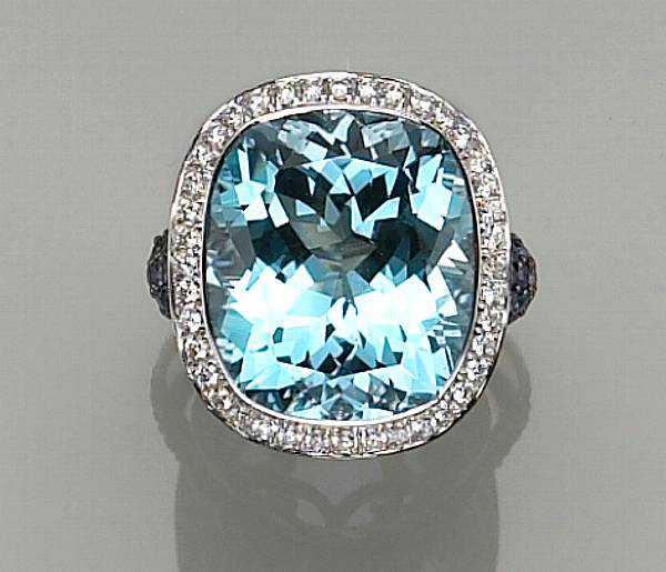 Appraisal: centering a cushion-cut collet-set blue topaz framed by round brilliant-cut