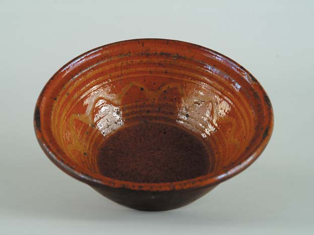 Appraisal: SLIP DECORATED REDWARE BOWL Bowl has molded rim on a