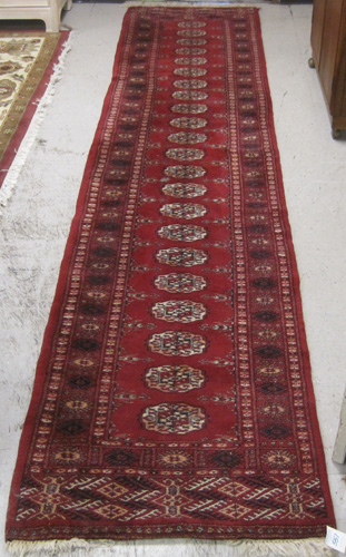 Appraisal: RED FIELD PAKISTANI BOKHARA RUNNER hand knotted ' x '