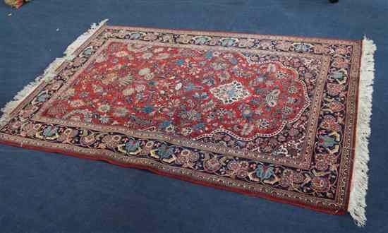 Appraisal: A Persian rug with field of scrolling foliage with vase