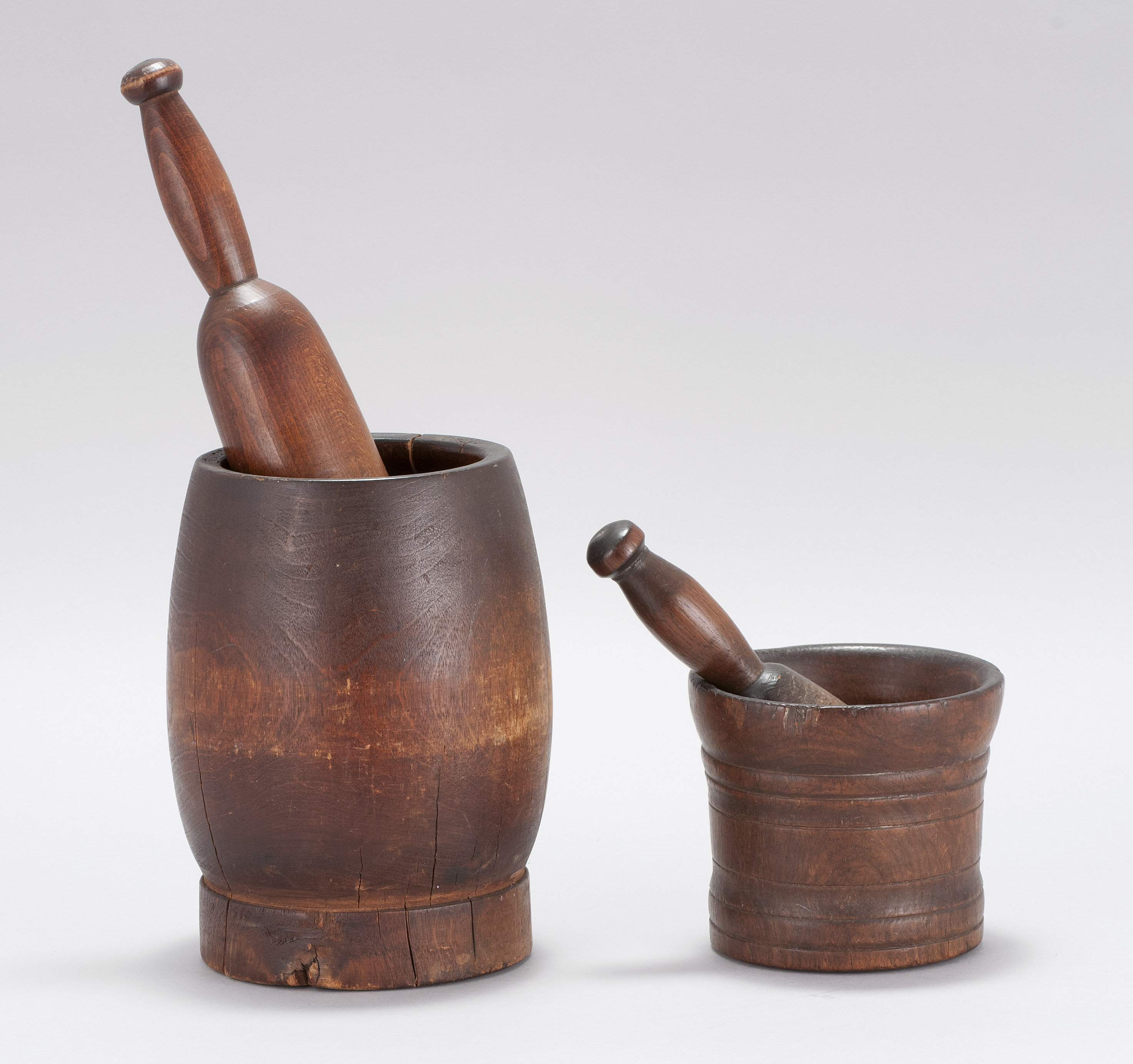 Appraisal: TWO WOODEN MORTARS AND PESTLES th CenturyBoth with dark brown