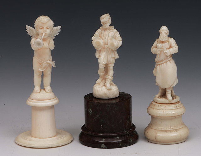 Appraisal: A miniature European carved ivory model of a figure holding