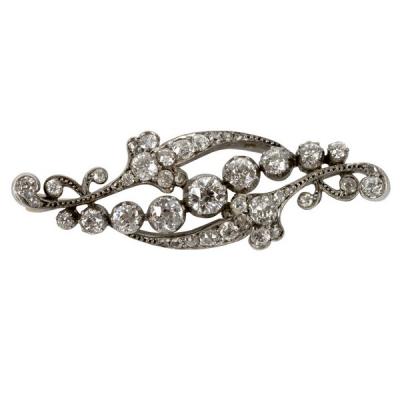 Appraisal: A diamond brooch of scrolling form the central line of