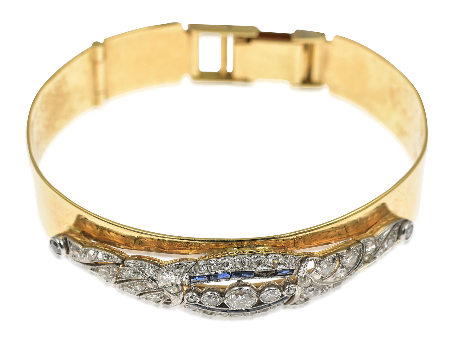 Appraisal: A DIAMOND AND SAPPHIRE BANGLE The oval hinged bangle overlaid