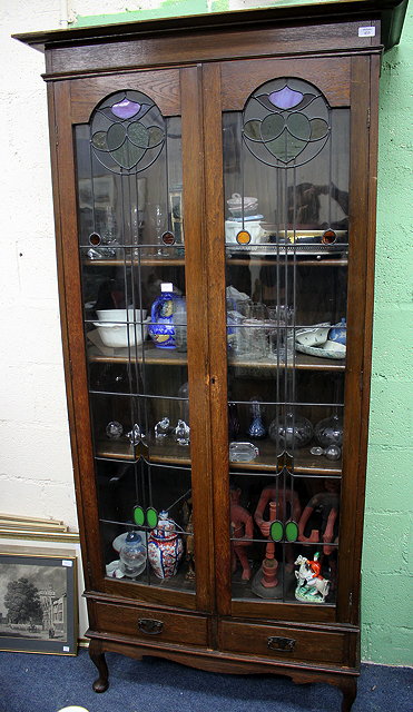 Appraisal: AN ART NOUVEAU OAK BOOKCASE CABINET with twin glazed doors