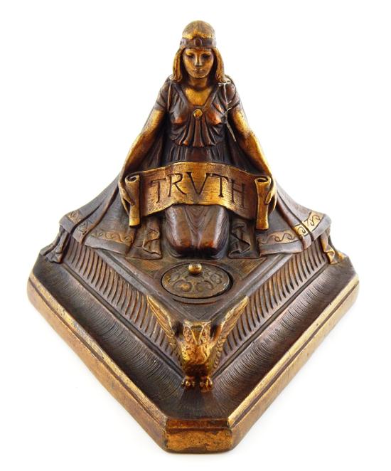 Appraisal: Tri-cornered inkwell with kneeling maiden holding banner reading TRUTH copper-colored