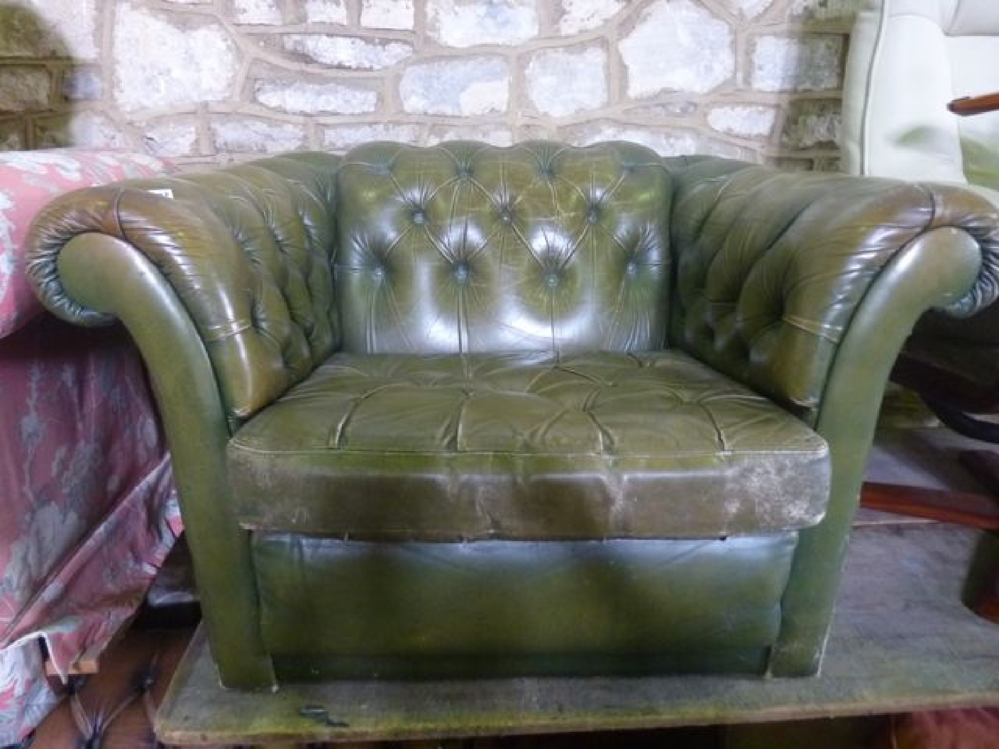 Appraisal: A green leather and buttoned upholstered Chesterfield type armchair with