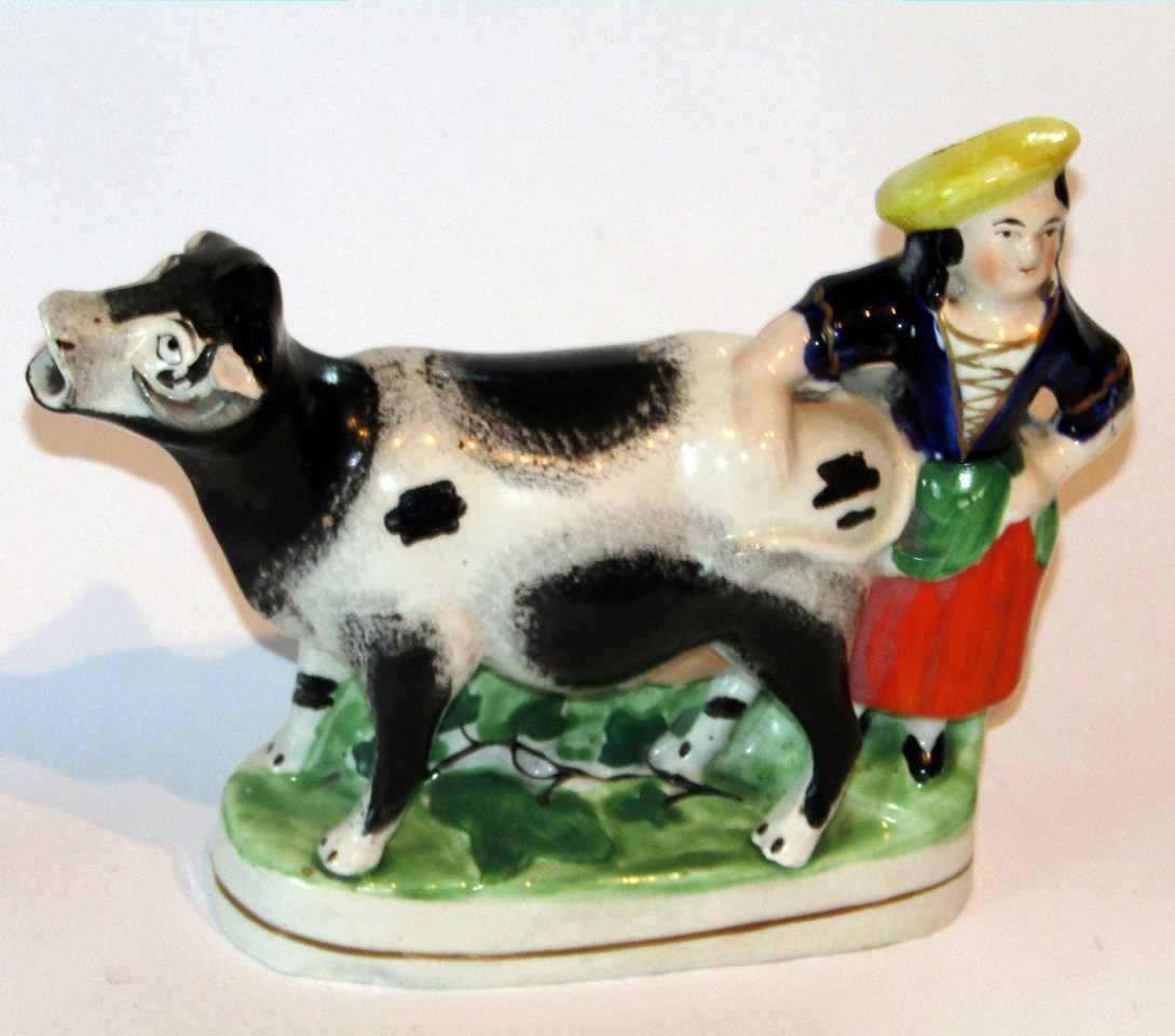 Appraisal: A mid- thC Staffordshire maid and cow figure group polychrome