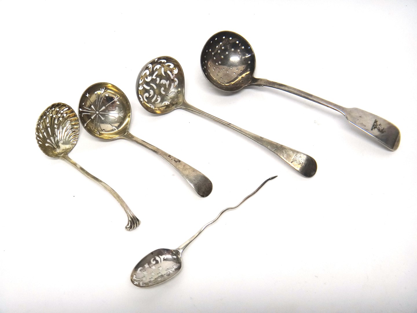 Appraisal: A silver mote spoon with pierced decoration three silver sugar