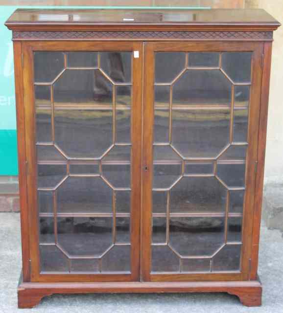 Appraisal: AN EDWARDIAN MAHOGANY BOOKCASE enclosed by two glazed panel doors