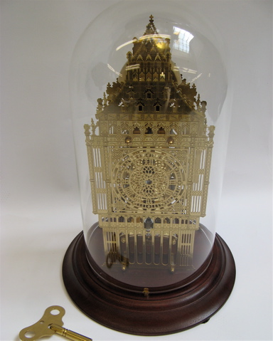 Appraisal: BRASS SKELETON CLOCK UNDER GLASS having bell strike on the