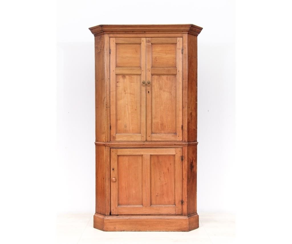 Appraisal: Pennsylvania walnut one-piece corner cupboard circa with raised paneled doors