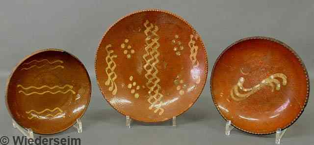 Appraisal: Three Pennsylvania redware pie plates each with yellow slip decoration