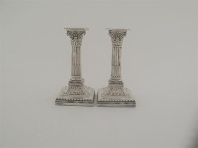 Appraisal: A pair of Edwardian dwarf column candlesticks on bevelled square