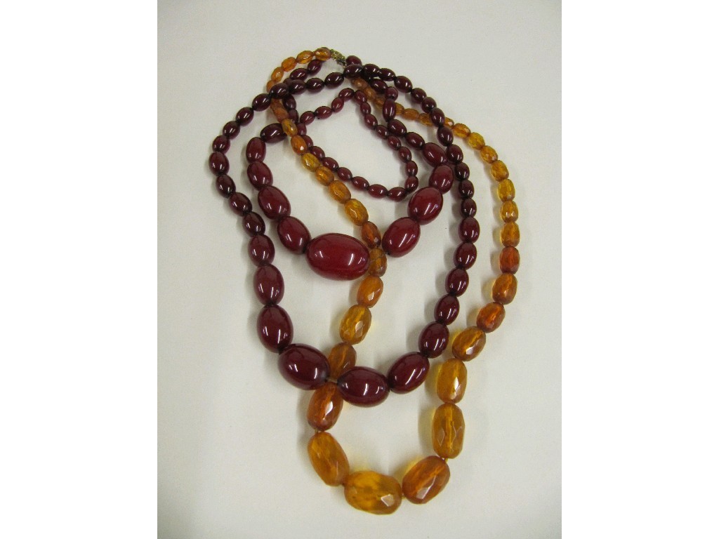 Appraisal: Two strings of red amber beads a red amber bead