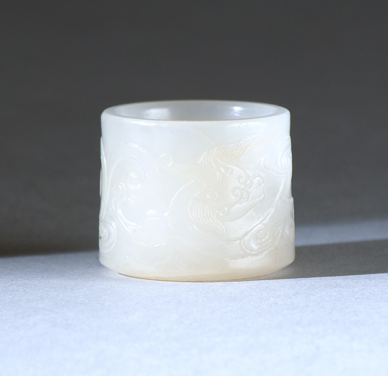 Appraisal: WHITE JADE ARCHER'S RING th CenturyWith stylized creature carved throughout