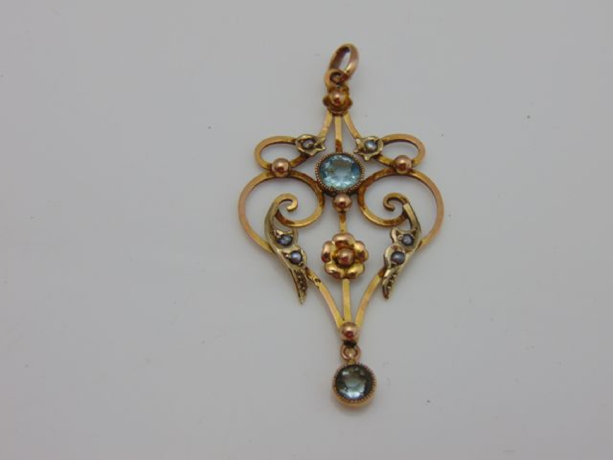 Appraisal: An Edwardian aquamarine and seed pearl drop pendant the scrolling