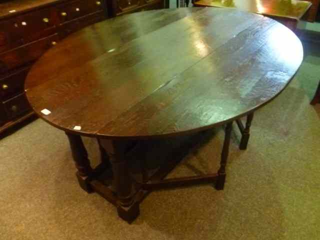 Appraisal: A LARGE OAK DINING TABLE of oval form with drop