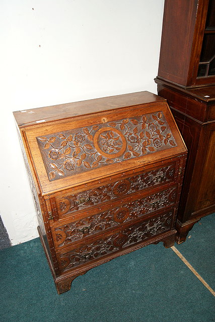 Appraisal: A CARVED WALNUT FALL FRONT BUREAU with leaf designs cm