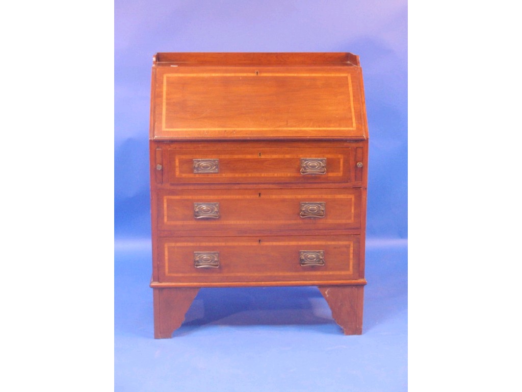 Appraisal: An Edwardian cross-banded walnut bureau with fall flap over three