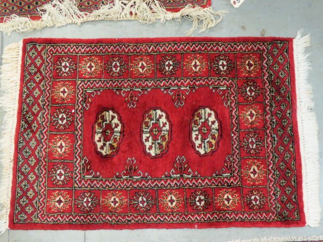 Appraisal: Bokara Pakistan Handmade Mat geometrics on rich red field '