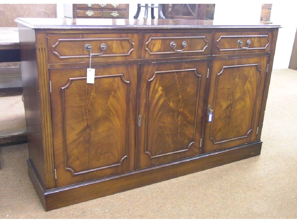 Appraisal: A reproduction mahogany veneered side cupboard three frieze drawers above