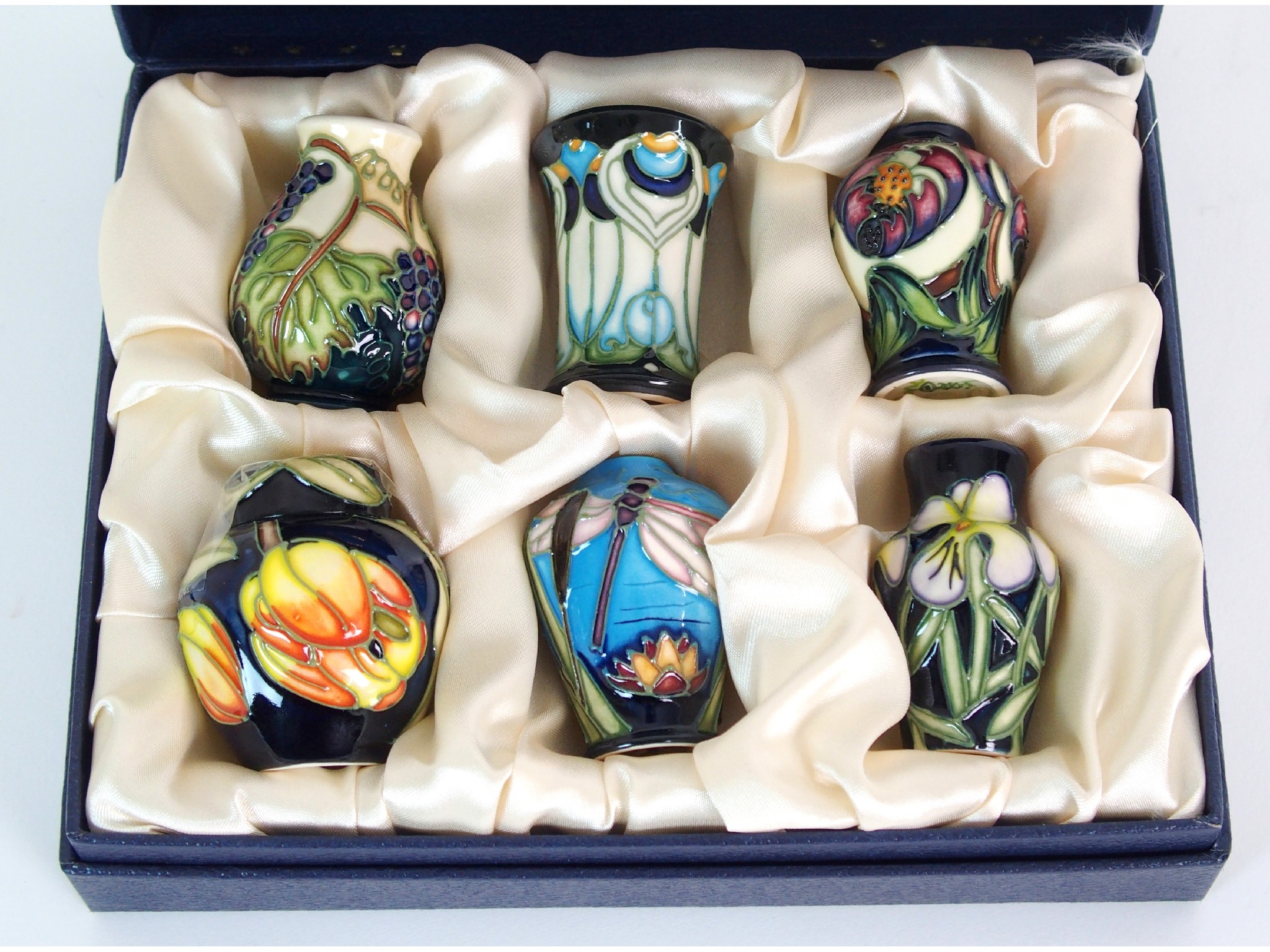 Appraisal: A set of six Moorcroft Pottery miniature vases and ginger