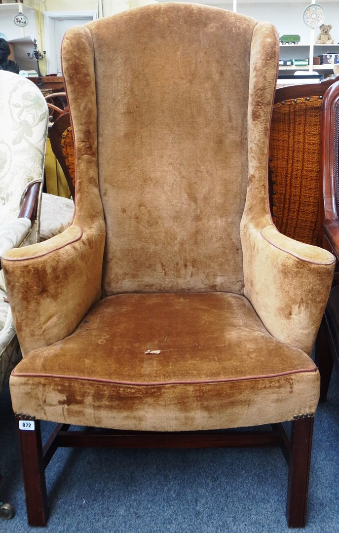 Appraisal: An th century style high wingback armchair with outswept arms