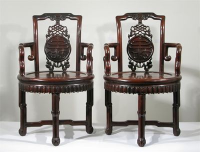 Appraisal: A pair of Chinese hardwood revolving open armchairs the splats