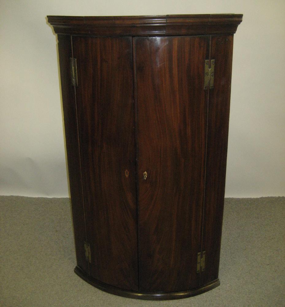 Appraisal: A GEORGE III MAHOGANY CORNER CUPBOARD c of bowed form