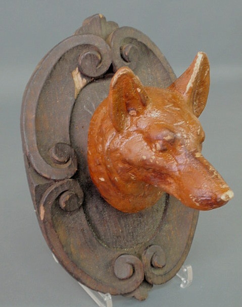 Appraisal: Carved wood fox head mounted on an ornately carved plaque