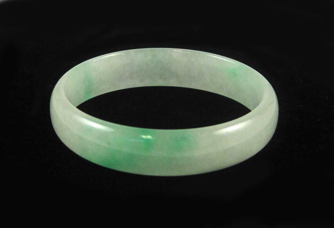 Appraisal: ROUND JADEITE JADE LIGHT GREEN BANGLE The two-tone light green